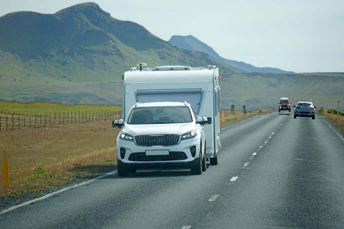 Car towing a trailer on a road in Iceland